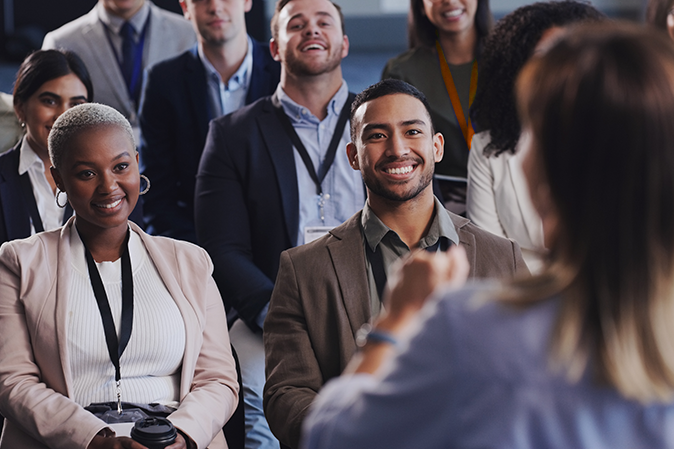 Legal professionals sitting at a conference listening to a female speaker