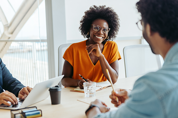 Group of professionals engages in a collaborative and creative brainstorming session in a modern boardroom. The team, led by the manager, discusses ideas and plans for a business project.